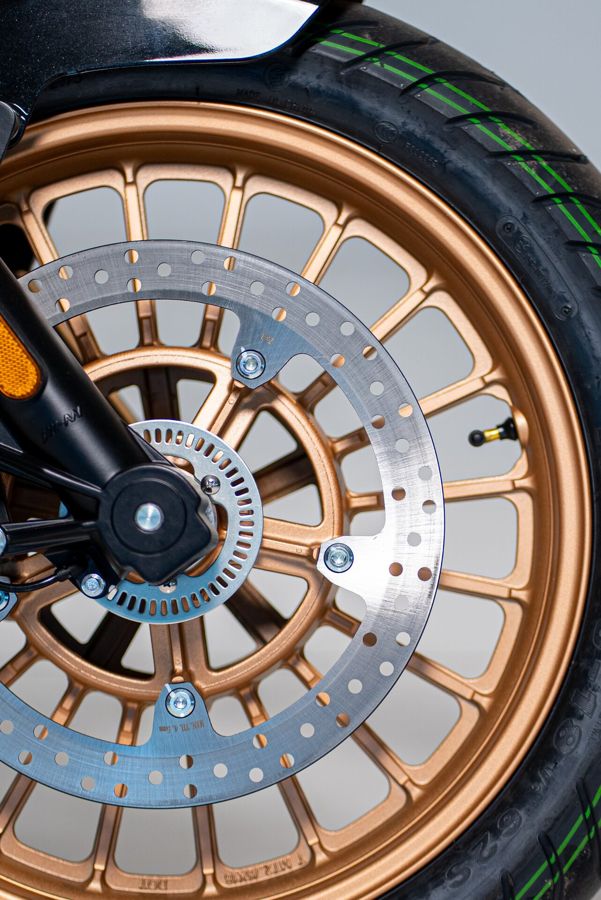Detalhe da roda dianteira em acabamento cobre com disco de freio